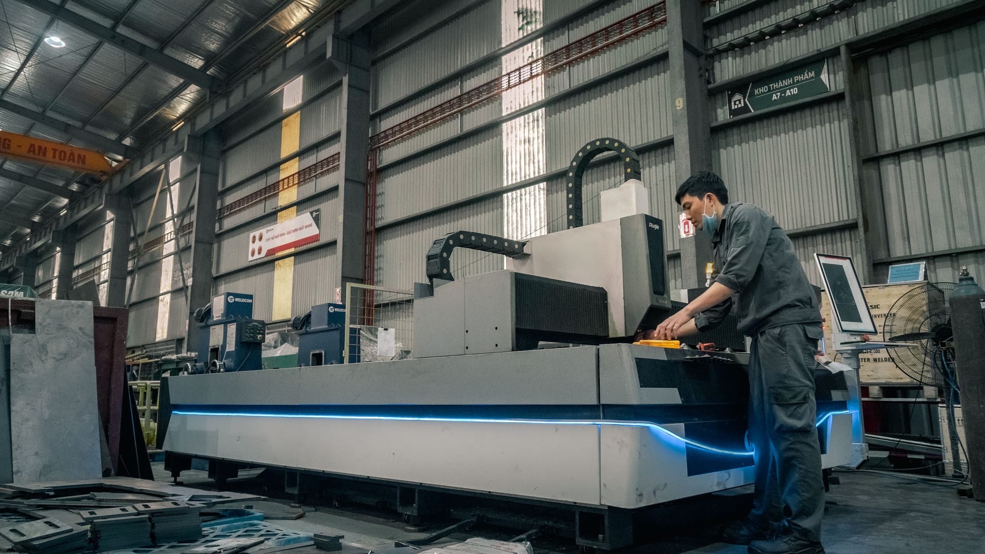 Maschinenbediener an einer CNC-Maschine in einer Produktionshalle