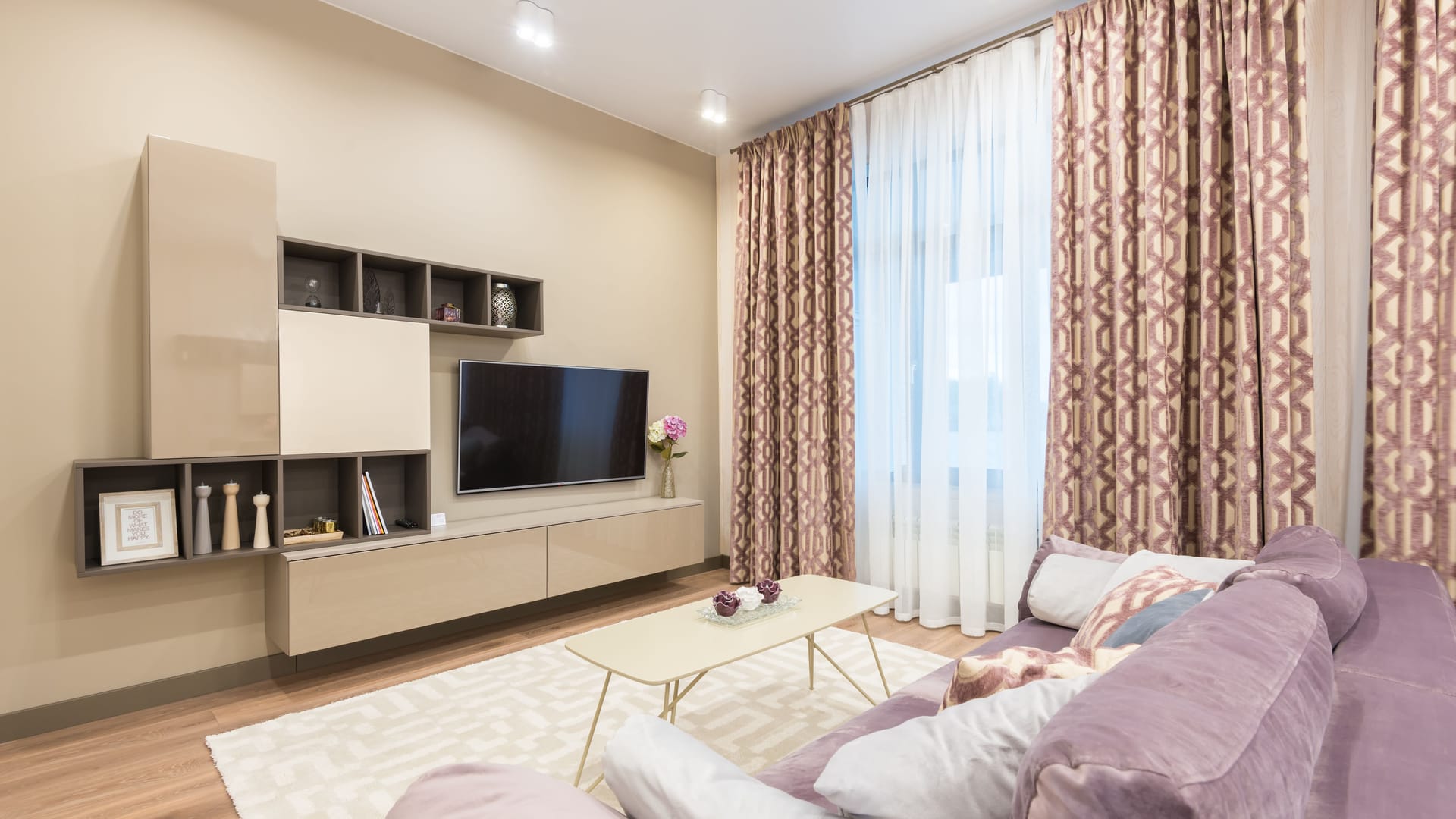 Wohnzimmer mit TV-Wand: Hängeschränke, offene Regale und ein Fernseher an der Wand